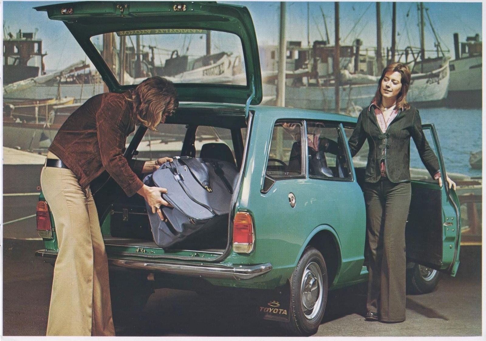 two women loading luggage into the back of a car
