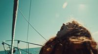 a woman sitting on a boat looking up at the sky