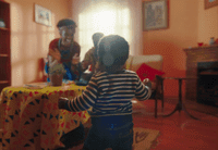 a young child standing in front of a table