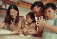 a group of people standing around a kitchen counter