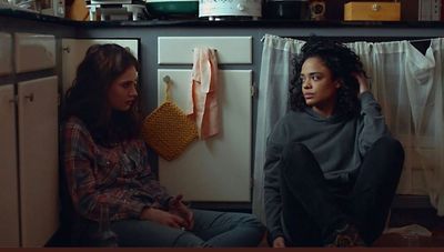a couple of women sitting next to each other in a kitchen