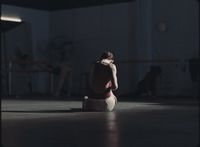 a woman sitting on the floor in a dark room