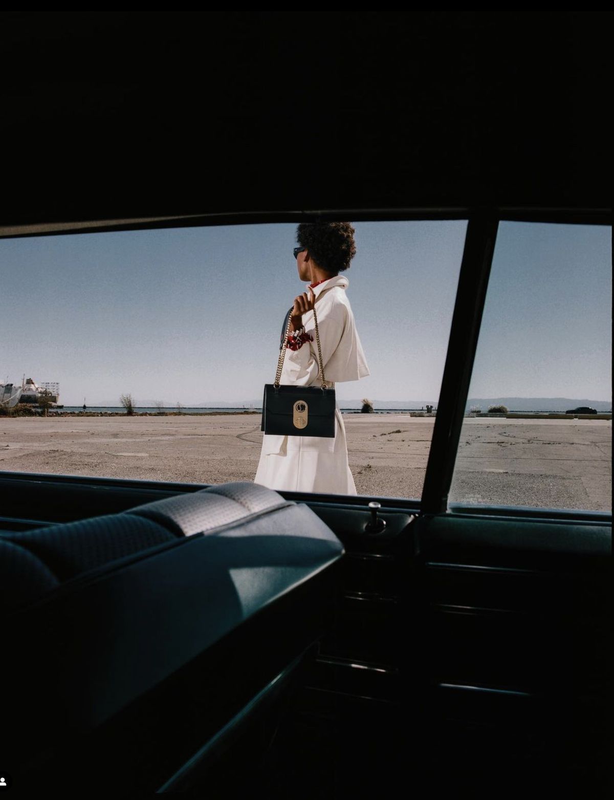 a woman in a white dress is standing in the back of a car