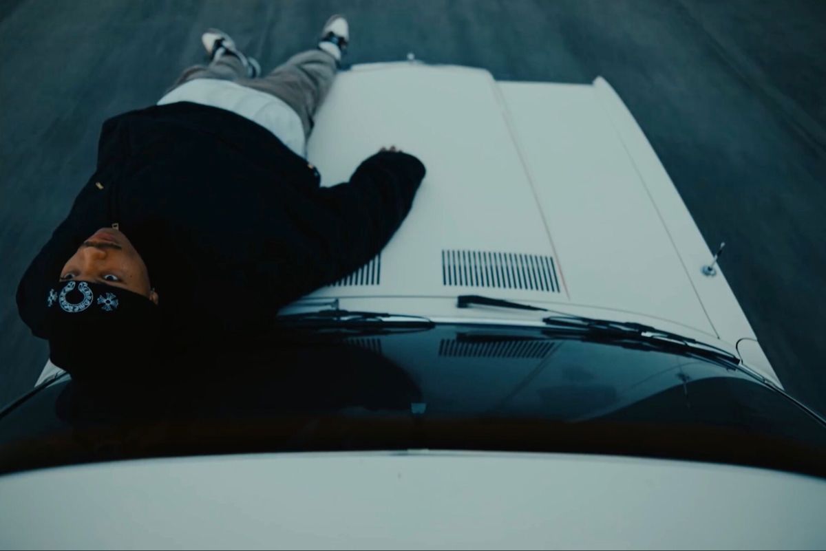 a person laying on the hood of a car