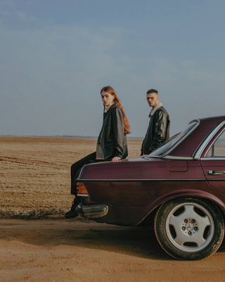 a man and a woman standing next to a car