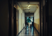 two people walking down a hallway in a building