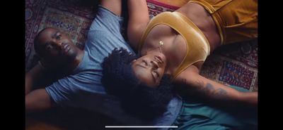 a couple of people laying on top of a couch