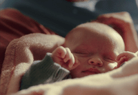 a close up of a baby sleeping on a blanket