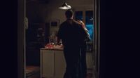 a man standing in a kitchen next to a woman