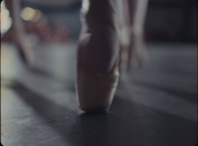 a close up of a ballerina's feet on a dance floor