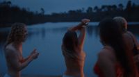 a group of women standing next to a body of water