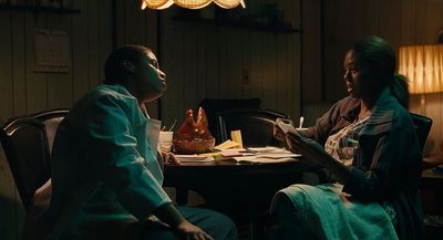 two people sitting at a table in a dark room