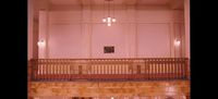 a large room with a balcony and a clock on the wall