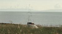 a car parked on the side of a hill near the ocean