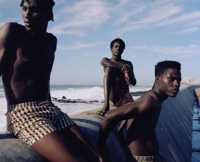a group of young men sitting on top of a boat