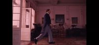 a man in a suit walking through a room