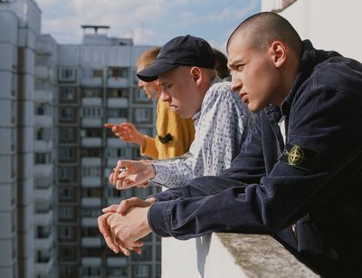 a couple of men sitting on top of a building