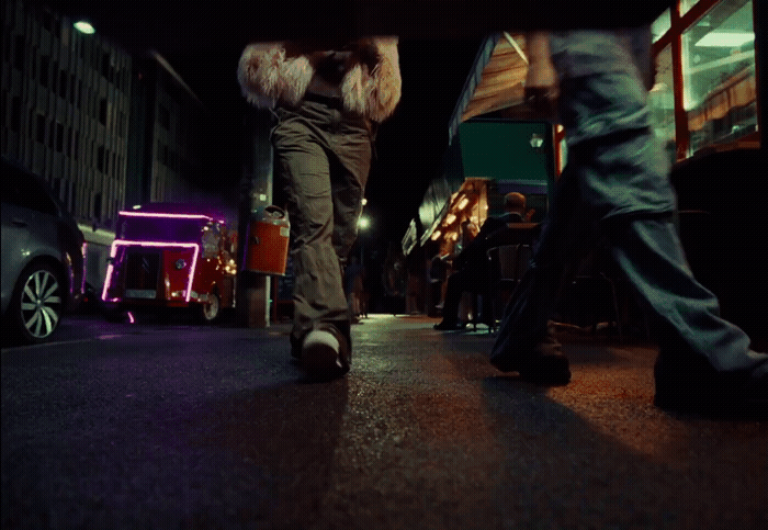 a couple of people walking down a street at night