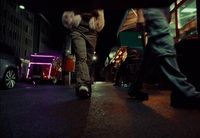 a couple of people walking down a street at night