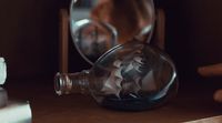 a glass bottle sitting on top of a wooden table