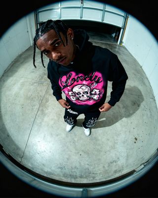a man in a black hoodie standing in a room