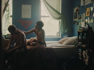 a couple of men sitting on top of a bed