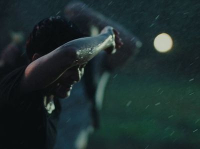 a person holding a baseball bat in the rain