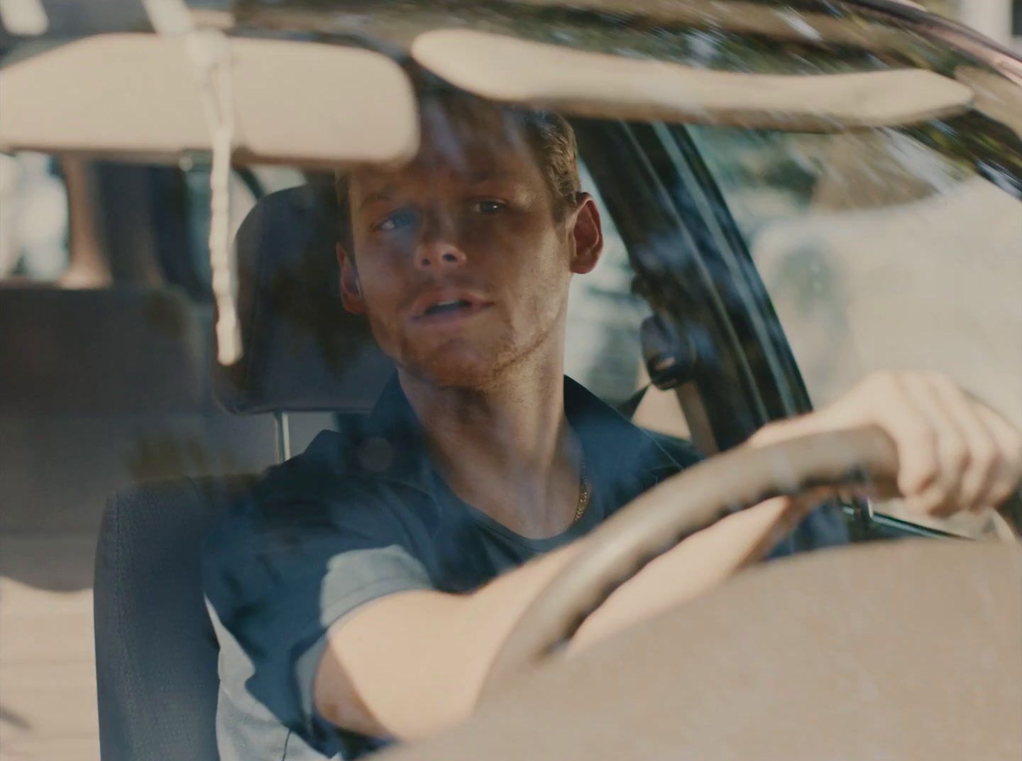 a man sitting in a car looking out the window