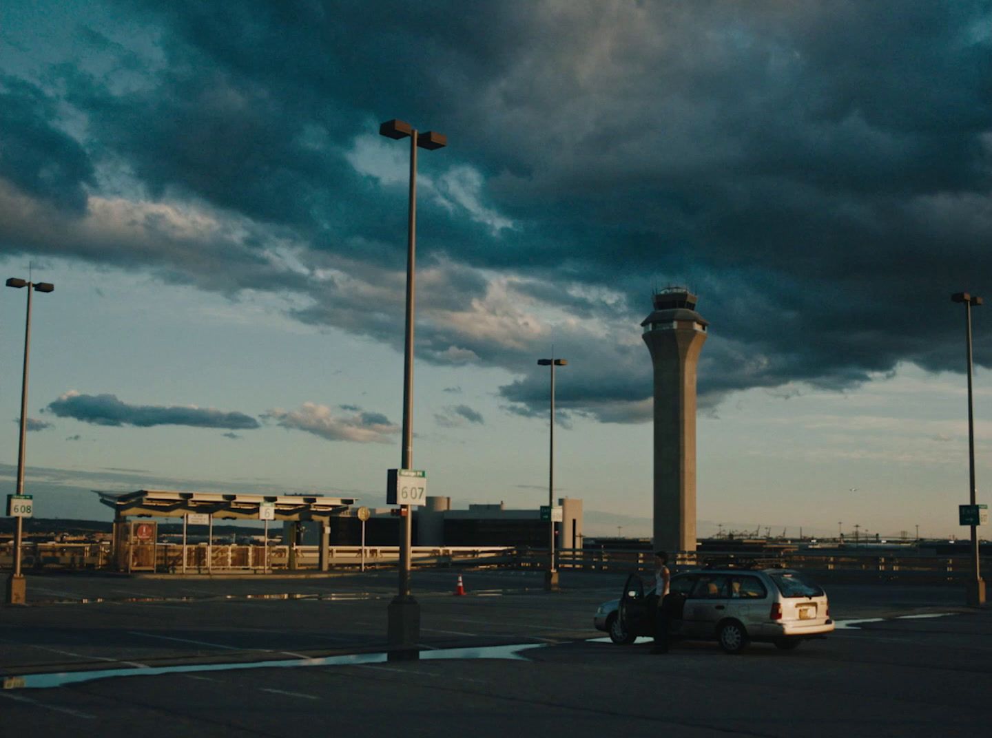 a car parked in a parking lot under a cloudy sky