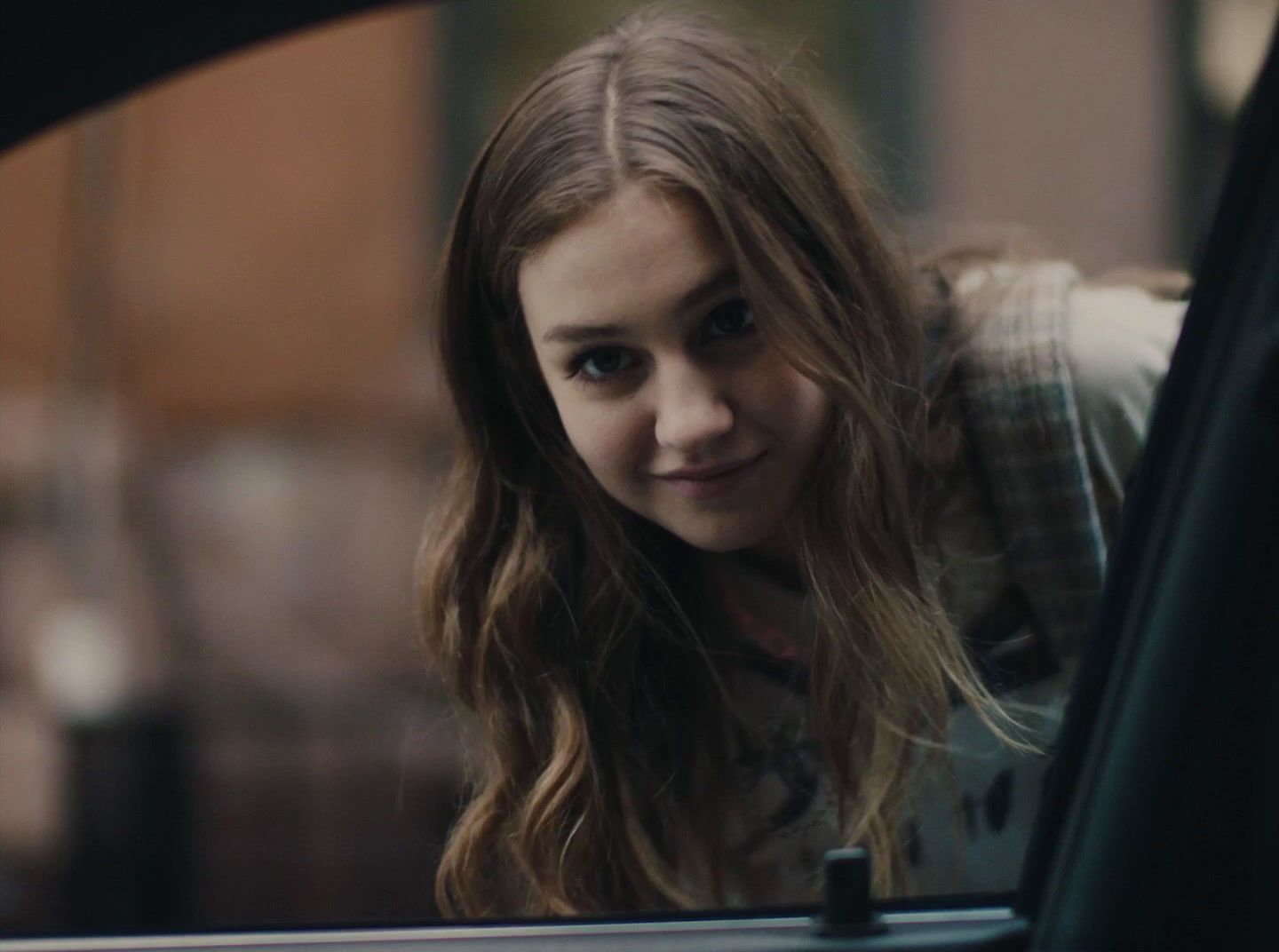 a young girl sitting in a car looking out the window