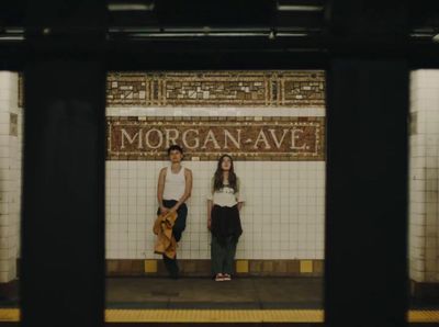 a couple of people standing on a subway platform