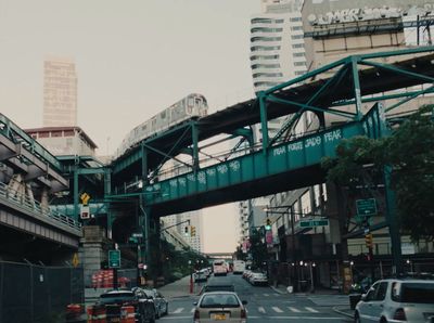 a city street filled with traffic under a bridge