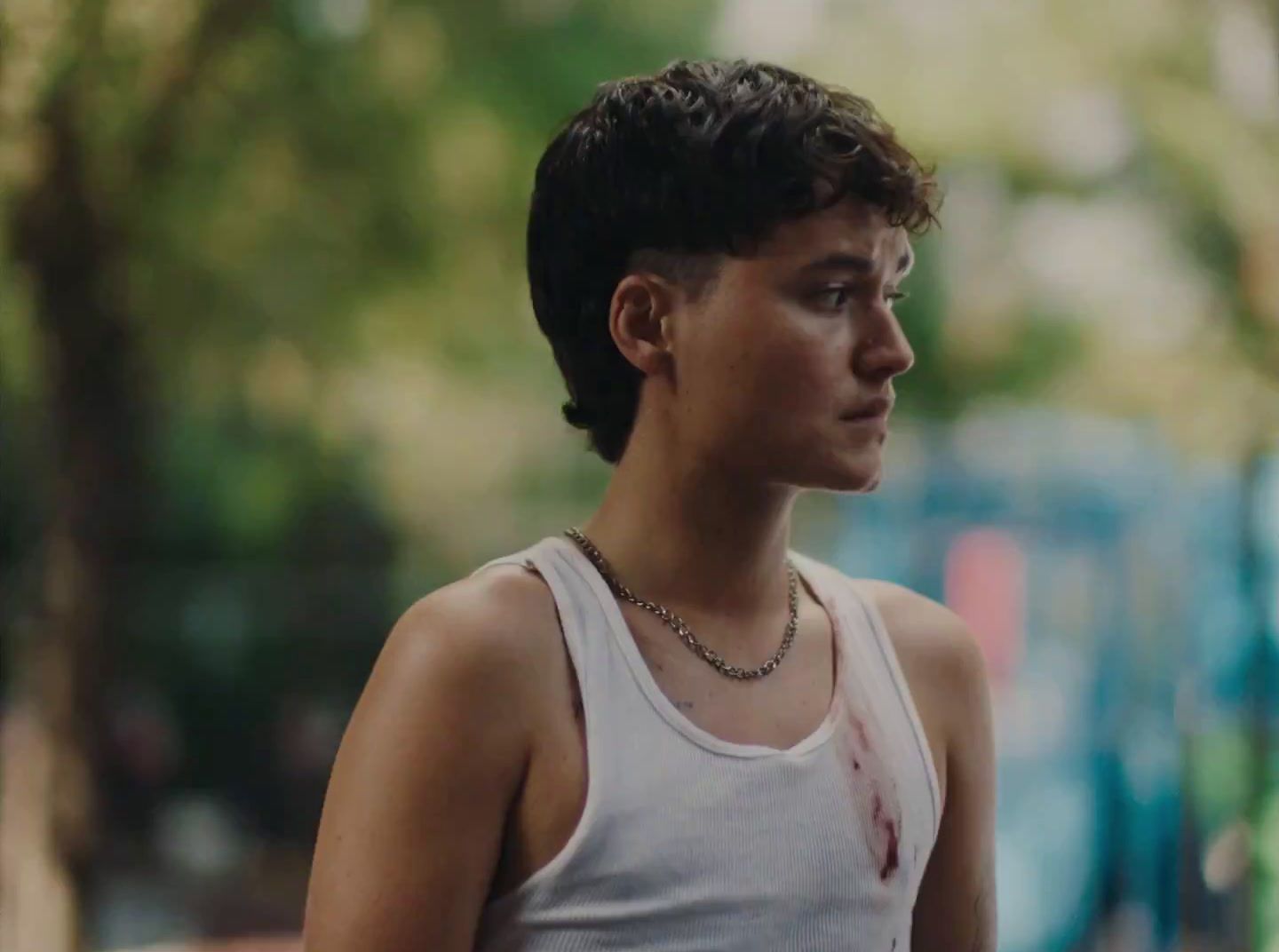 a young man wearing a white tank top