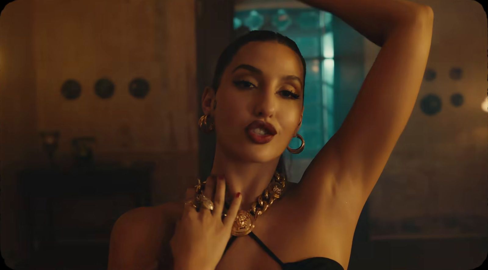 a woman in a black top and gold jewelry