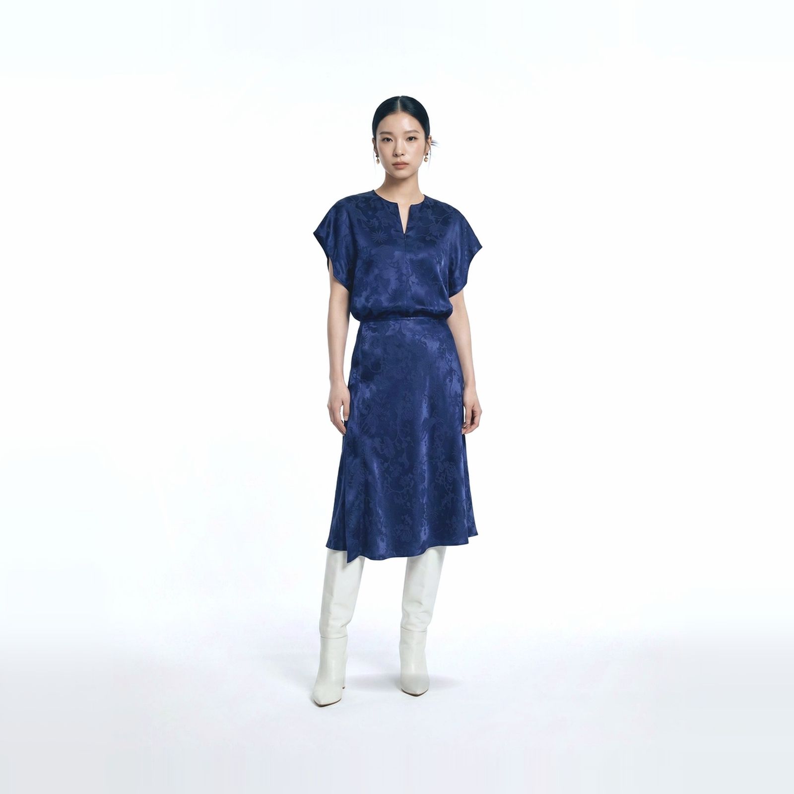 a woman wearing a blue dress and white boots