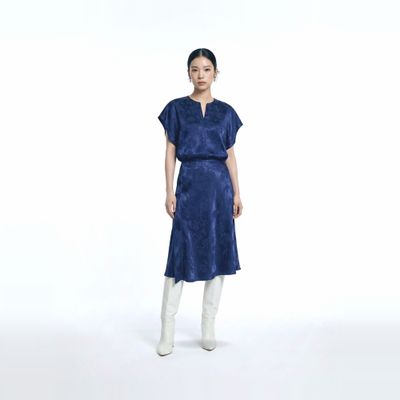 a woman wearing a blue dress and white boots