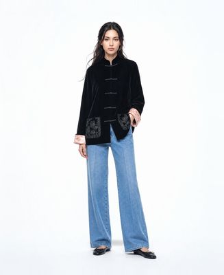 a woman wearing a black jacket and jeans