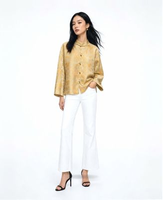 a woman in a yellow shirt and white pants