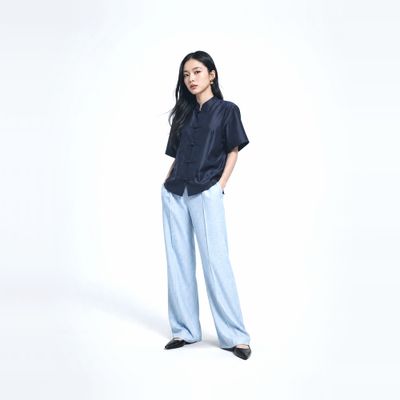 a woman standing with her hands in her pockets