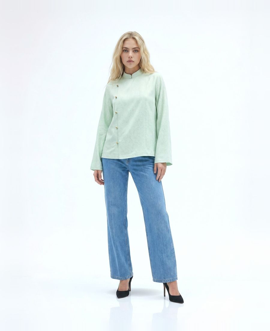 a woman wearing a green shirt and jeans