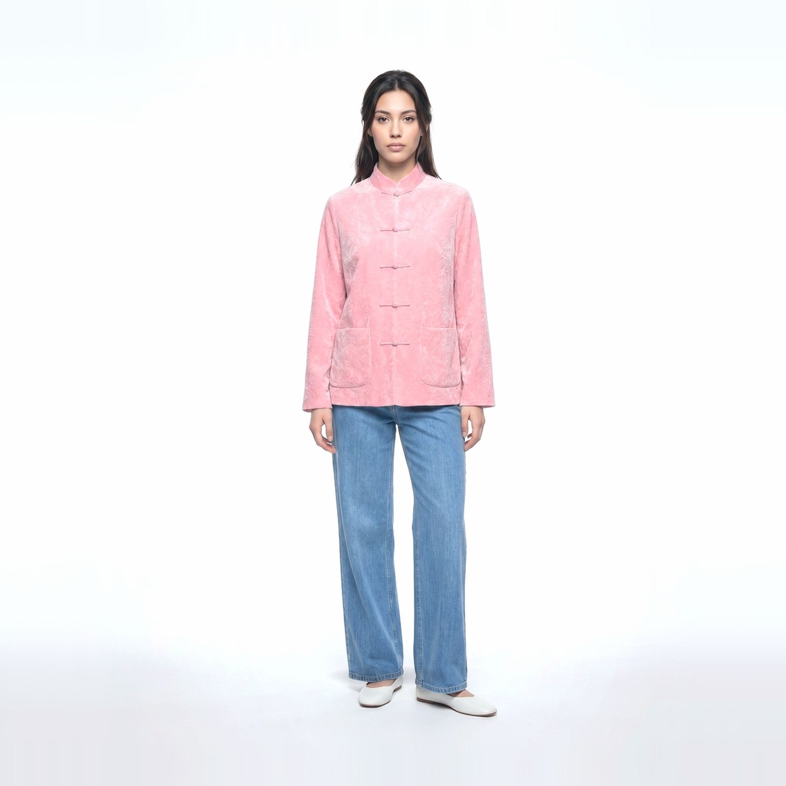 a woman wearing a pink jacket and jeans