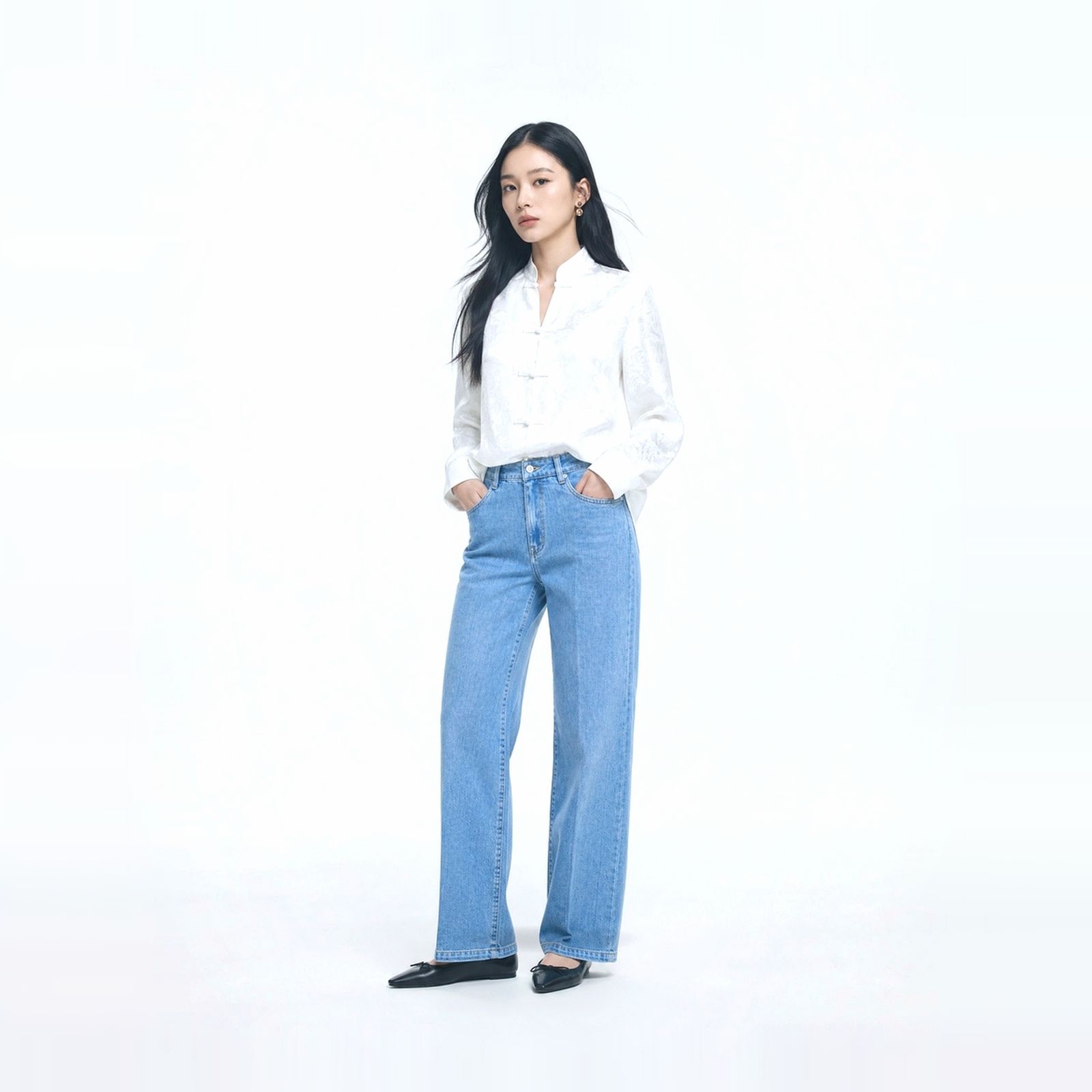 a woman standing in a white shirt and jeans