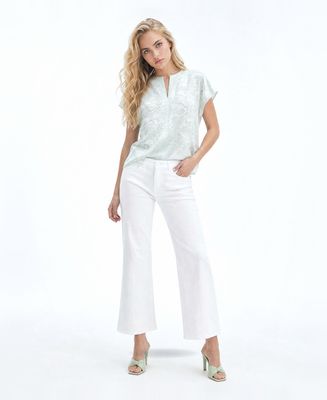 a woman in a white top and white pants