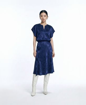 a woman wearing a blue dress and white boots
