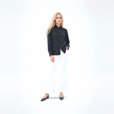 a woman in a black shirt and white pants