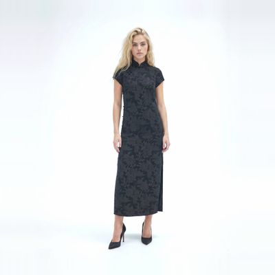 a woman in a black dress is posing for a picture