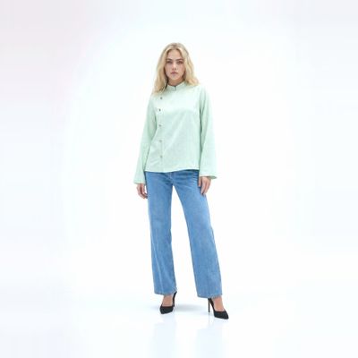 a woman in a light green shirt and jeans
