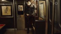 a man in a cowboy hat standing on a train