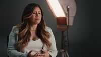 a woman is standing in front of a light