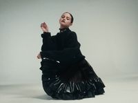 a woman in a black dress sitting on the ground